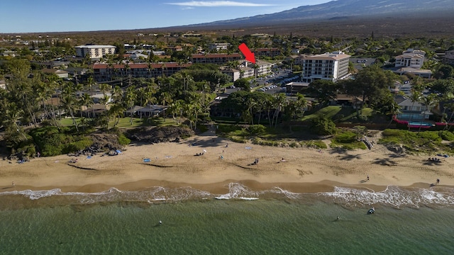 drone / aerial view with a water and mountain view and a view of the beach