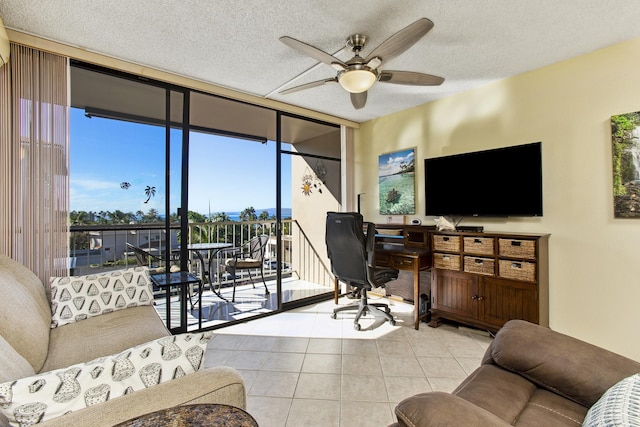 tiled home office with ceiling fan, a wall of windows, and a textured ceiling