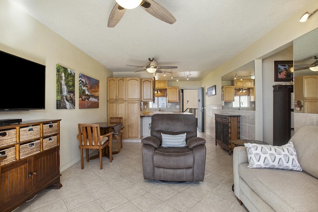 living room featuring light tile patterned flooring, a textured ceiling, and rail lighting