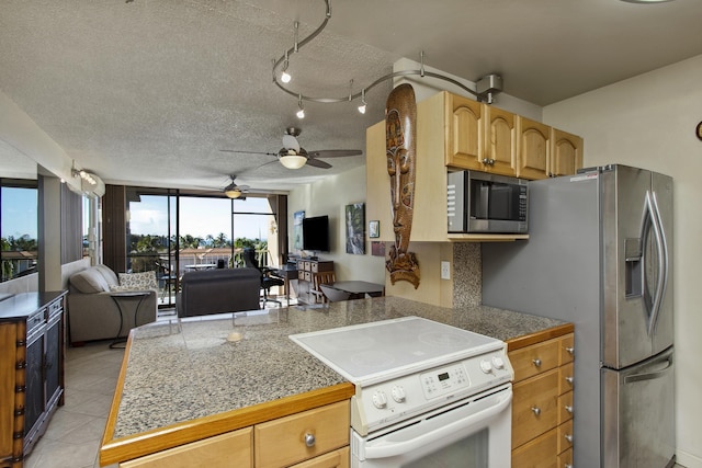 kitchen with kitchen peninsula, stainless steel appliances, decorative backsplash, light tile patterned flooring, and a textured ceiling