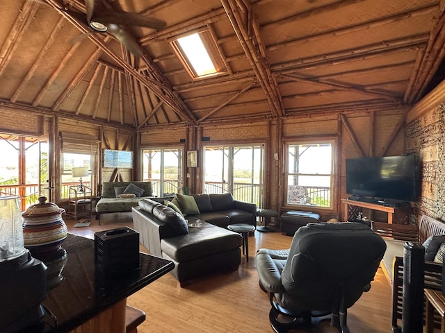 living room with light wood-style flooring and vaulted ceiling
