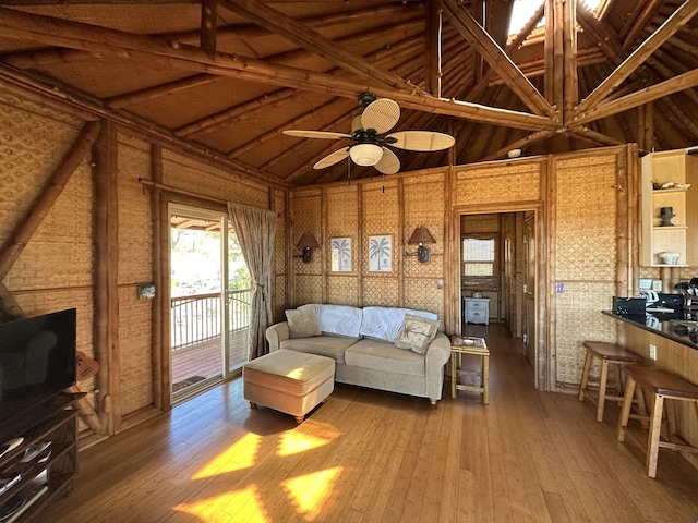 living area featuring vaulted ceiling, a ceiling fan, and hardwood / wood-style floors