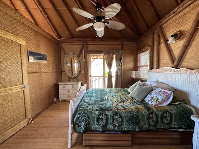unfurnished bedroom featuring lofted ceiling, a ceiling fan, light wood-style floors, and access to outside
