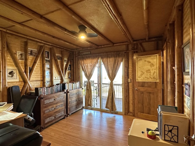 office space featuring wood walls, ceiling fan, and wood finished floors