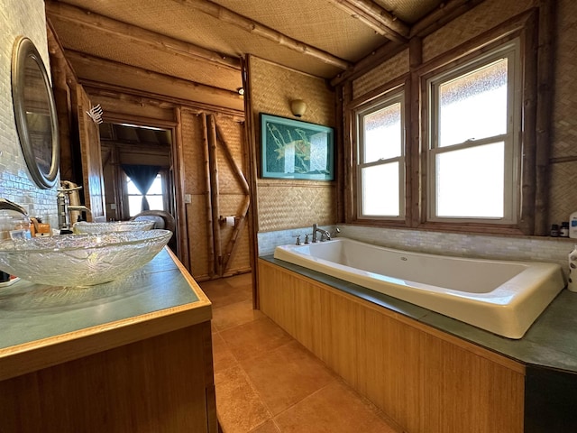 full bathroom with a garden tub, a healthy amount of sunlight, tile patterned flooring, and vanity