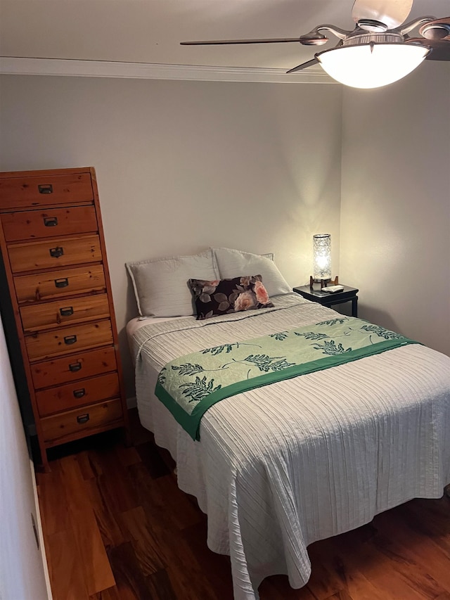 bedroom with ceiling fan, dark wood-type flooring, and crown molding