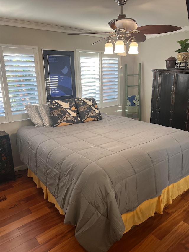 bedroom with multiple windows, crown molding, ceiling fan, and hardwood / wood-style flooring