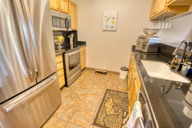 kitchen with light brown cabinetry, appliances with stainless steel finishes, and sink