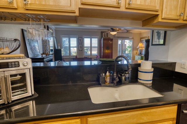 kitchen featuring a wall unit AC, crown molding, ceiling fan, and sink