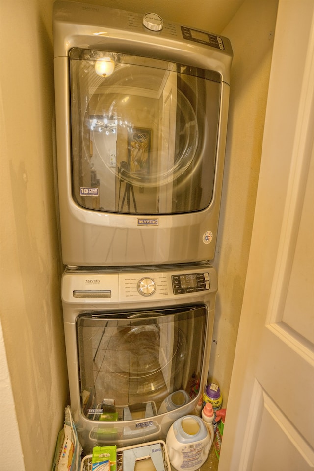 clothes washing area with stacked washer / dryer