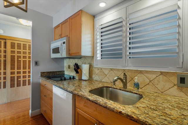 kitchen with stone counters, sink, white appliances, decorative backsplash, and ornamental molding