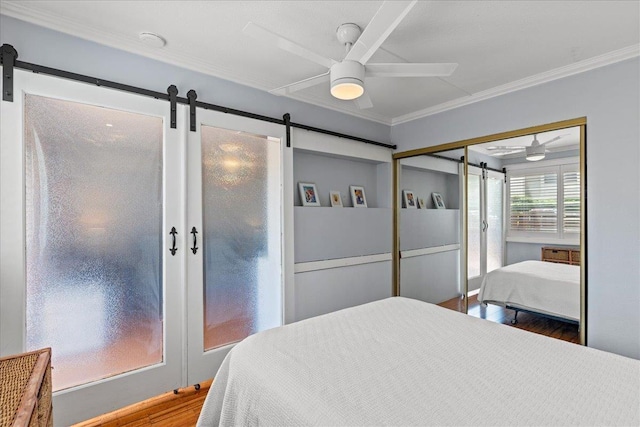 bedroom featuring crown molding, ceiling fan, a closet, and wood-type flooring