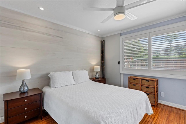 bedroom featuring ceiling fan, wood-type flooring, and ornamental molding