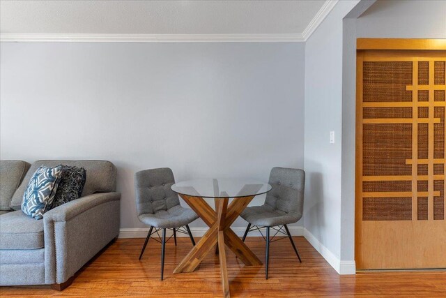 living area featuring crown molding and hardwood / wood-style flooring