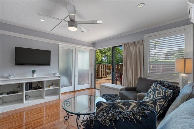 living room featuring hardwood / wood-style floors, french doors, ceiling fan, and crown molding