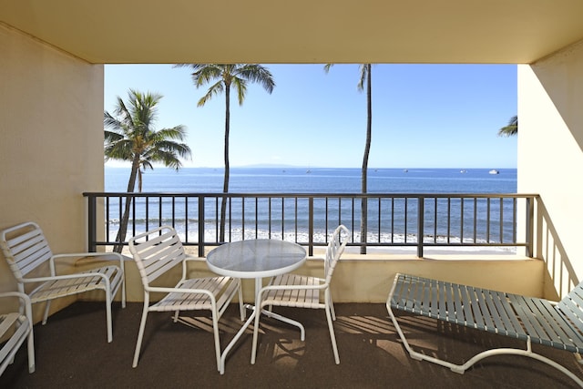 balcony featuring a water view and a beach view