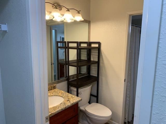 bathroom featuring vanity, toilet, and curtained shower