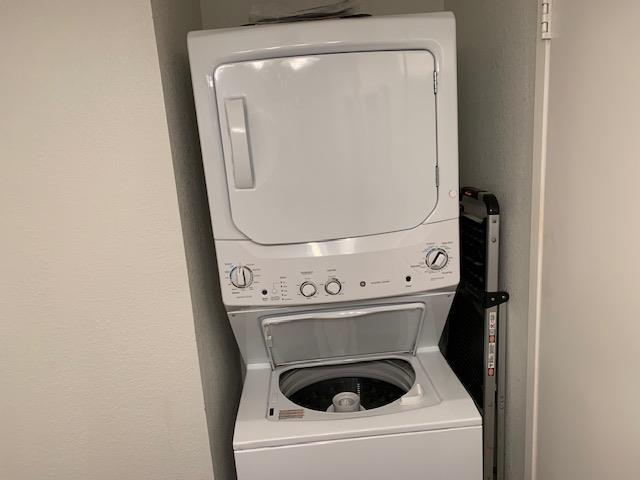 laundry room with stacked washing maching and dryer