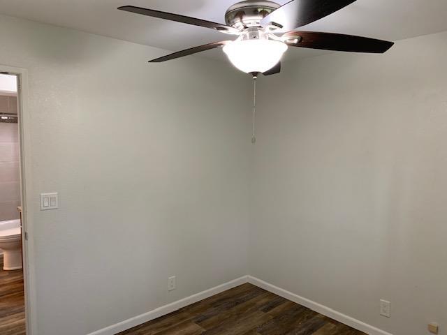 spare room featuring ceiling fan and dark hardwood / wood-style floors