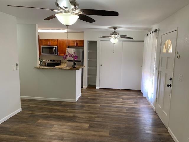 kitchen featuring kitchen peninsula, stainless steel appliances, and dark hardwood / wood-style floors