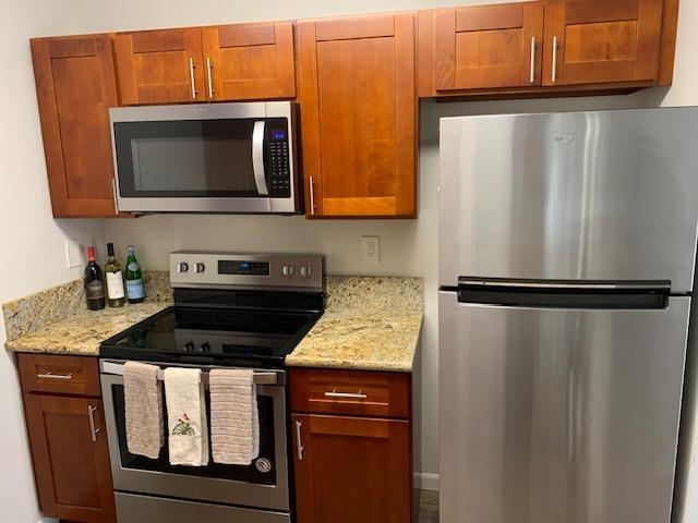 kitchen with light stone counters and stainless steel appliances