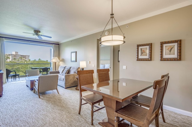 dining room with light carpet, ceiling fan, crown molding, and a textured ceiling