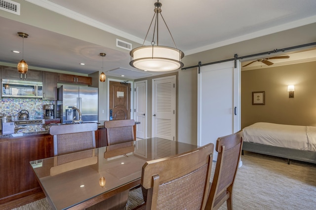 dining room with crown molding and a barn door