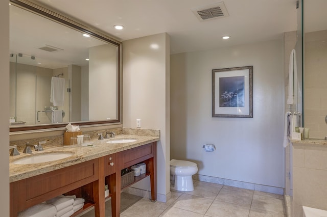 bathroom featuring tile patterned floors, toilet, vanity, and a tile shower