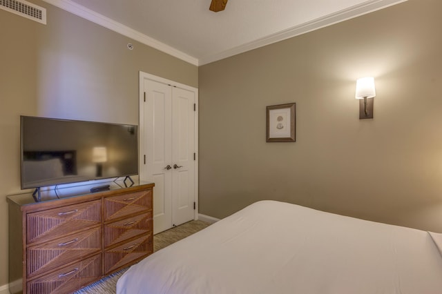 bedroom featuring ornamental molding, ceiling fan, and a closet