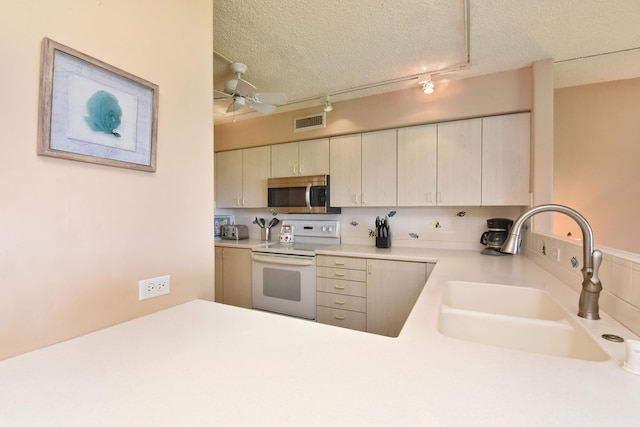 kitchen featuring ceiling fan, white range with electric stovetop, sink, kitchen peninsula, and rail lighting