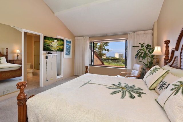 tiled bedroom featuring ensuite bath and vaulted ceiling