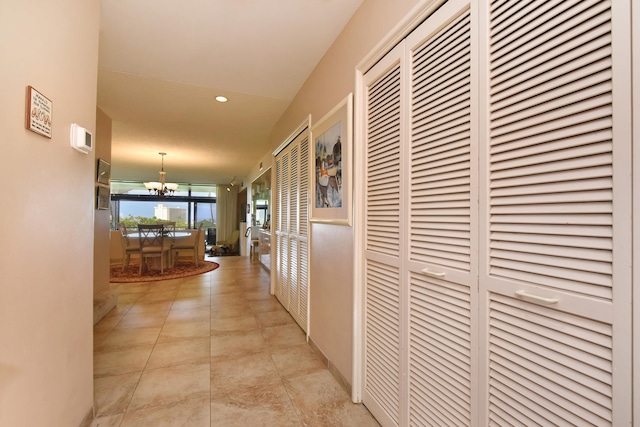 hall featuring an inviting chandelier and light tile floors