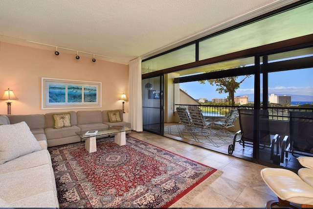 tiled living room with a textured ceiling, rail lighting, and expansive windows