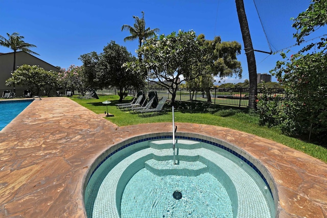 view of swimming pool with an in ground hot tub and a yard