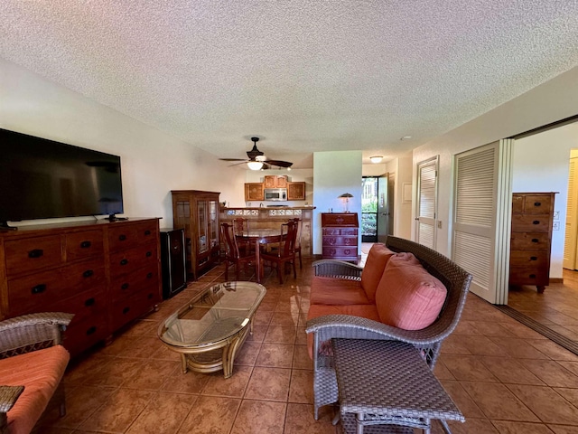 50 Kepuhi Pl Unit 103, Maunaloa, HI 96770 - living room featuring tile patterned floors, a ceiling fan, and a textured ceiling