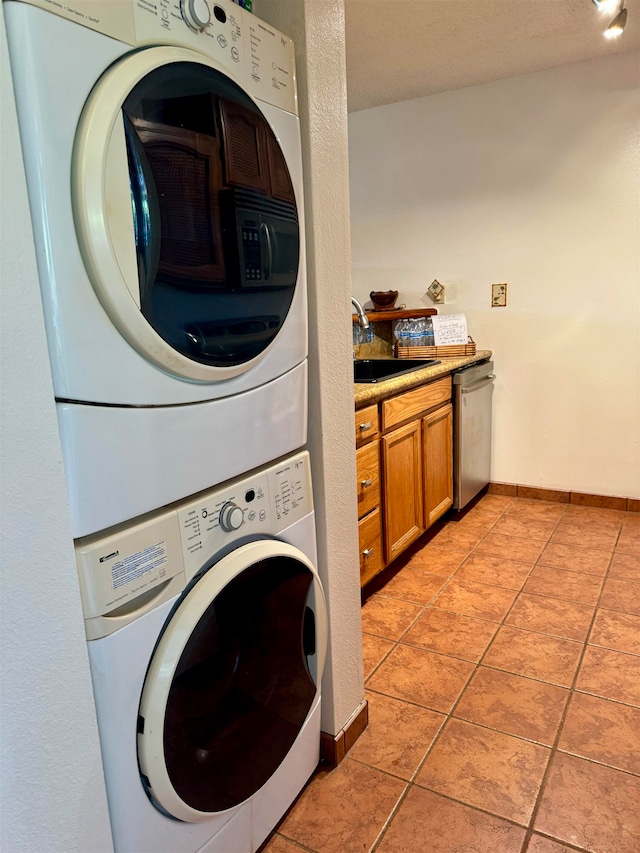 laundry room with stacked washer / drying machine, light tile patterned floors, and sink