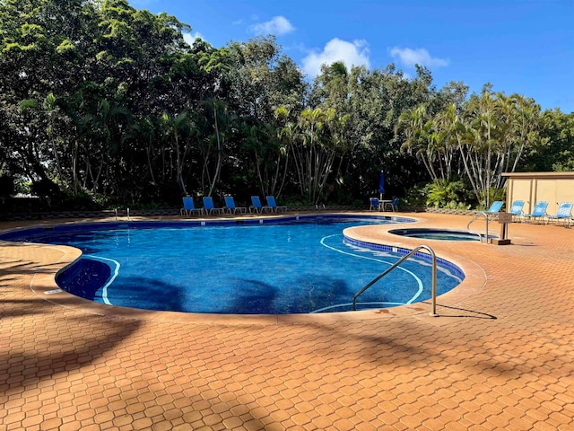 view of swimming pool with a patio area and a hot tub