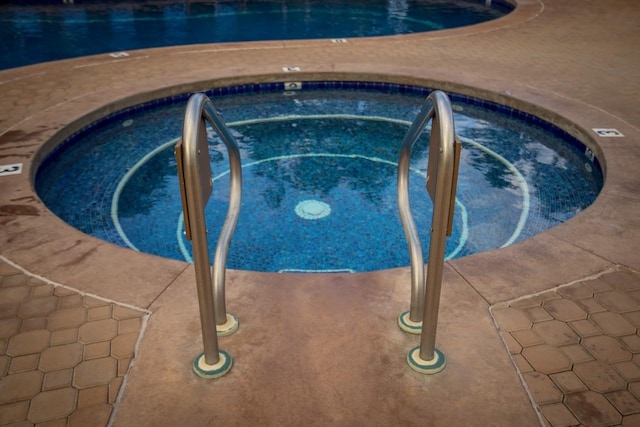 view of swimming pool featuring an in ground hot tub