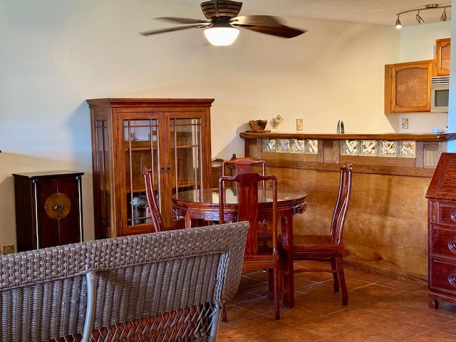 tiled dining space with ceiling fan