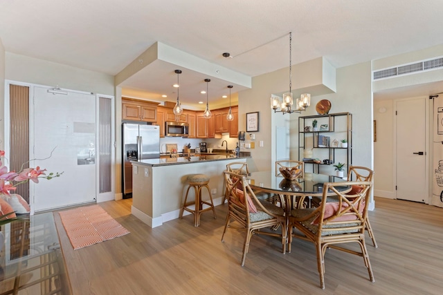 dining room featuring an inviting chandelier and light wood-type flooring