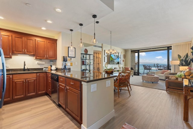 kitchen featuring kitchen peninsula, pendant lighting, an inviting chandelier, dishwasher, and light hardwood / wood-style floors