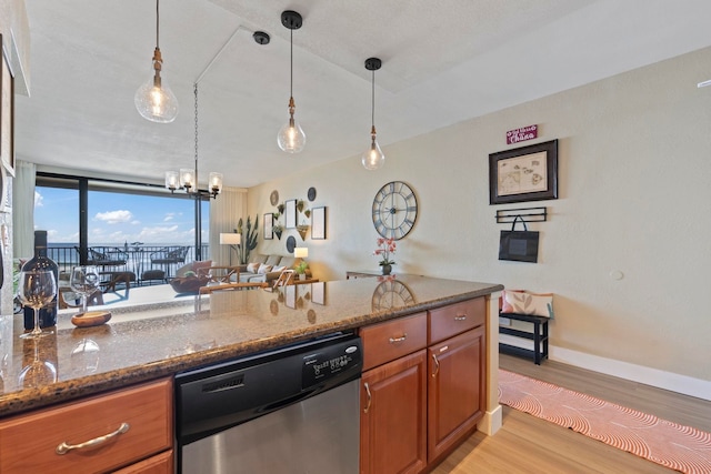 kitchen featuring hanging light fixtures, expansive windows, stainless steel dishwasher, dark stone counters, and light wood-type flooring