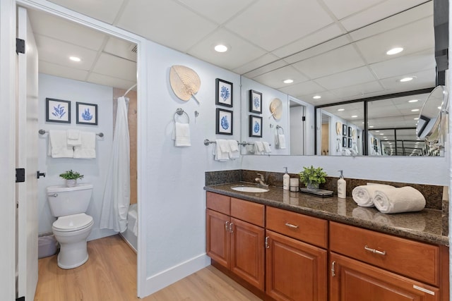 full bathroom with vanity, hardwood / wood-style flooring, toilet, and a paneled ceiling