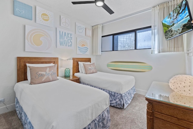 carpeted bedroom featuring ceiling fan and a textured ceiling