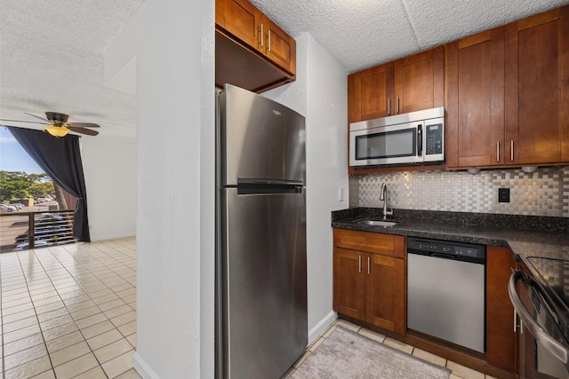 3676 Lower Honoapiilani Rd Unit G302, Lahaina, HI 96761 - kitchen featuring stainless steel appliances, light tile patterned flooring, decorative backsplash, a textured ceiling, and brown cabinetry
