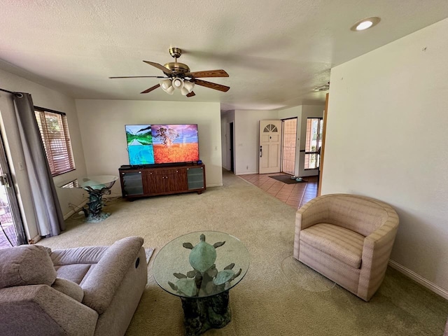 carpeted living room featuring ceiling fan, plenty of natural light, and a textured ceiling