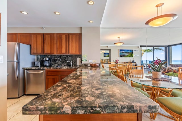 110 Kaanapali Shores Pl Unit 308, Lahaina, HI 96761 - kitchen with appliances with stainless steel finishes, brown cabinetry, a peninsula, recessed lighting, and decorative light fixtures
