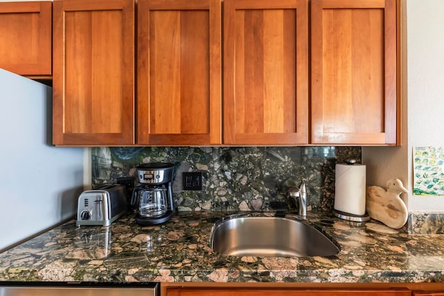 110 Kaanapali Shores Pl Unit 308, Lahaina, HI 96761 - kitchen featuring decorative backsplash, brown cabinets, a sink, and dark stone countertops