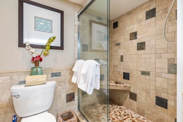 110 Kaanapali Shores Pl Unit 308, Lahaina, HI 96761 - bathroom featuring tile walls, a shower stall, toilet, and a wainscoted wall