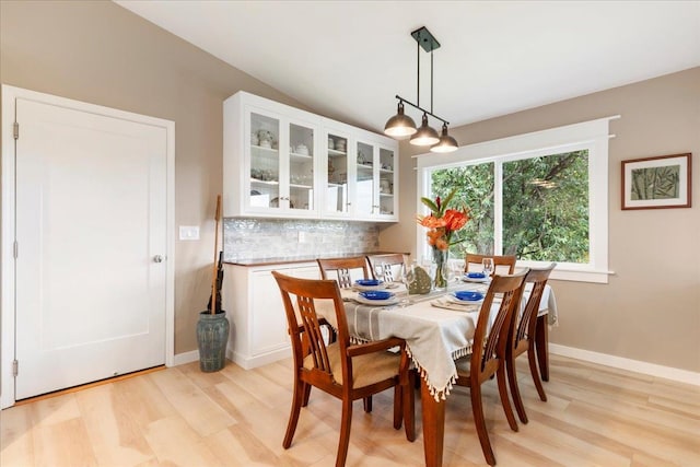 dining space featuring lofted ceiling and light hardwood / wood-style floors